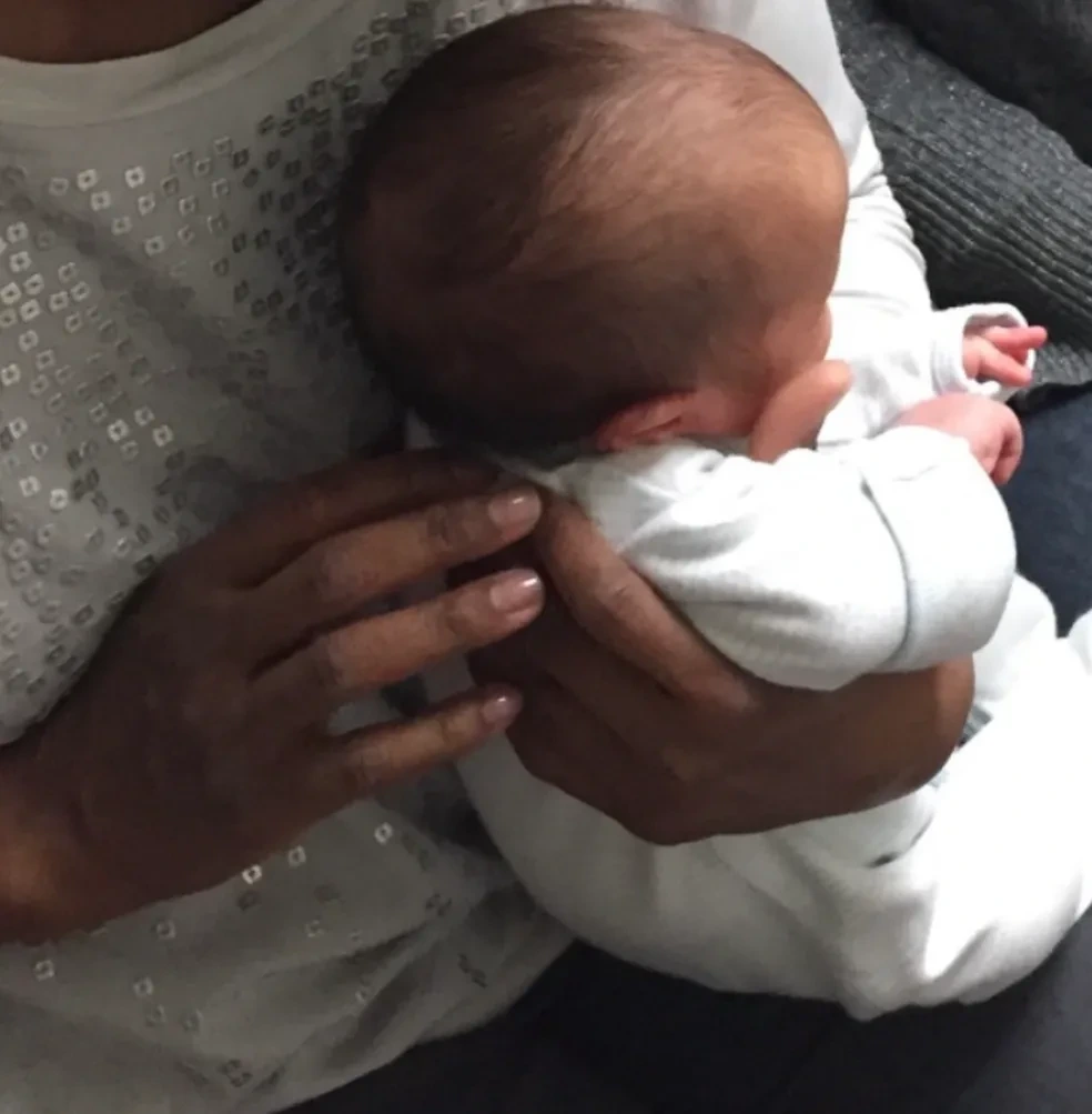 Newborn held gently